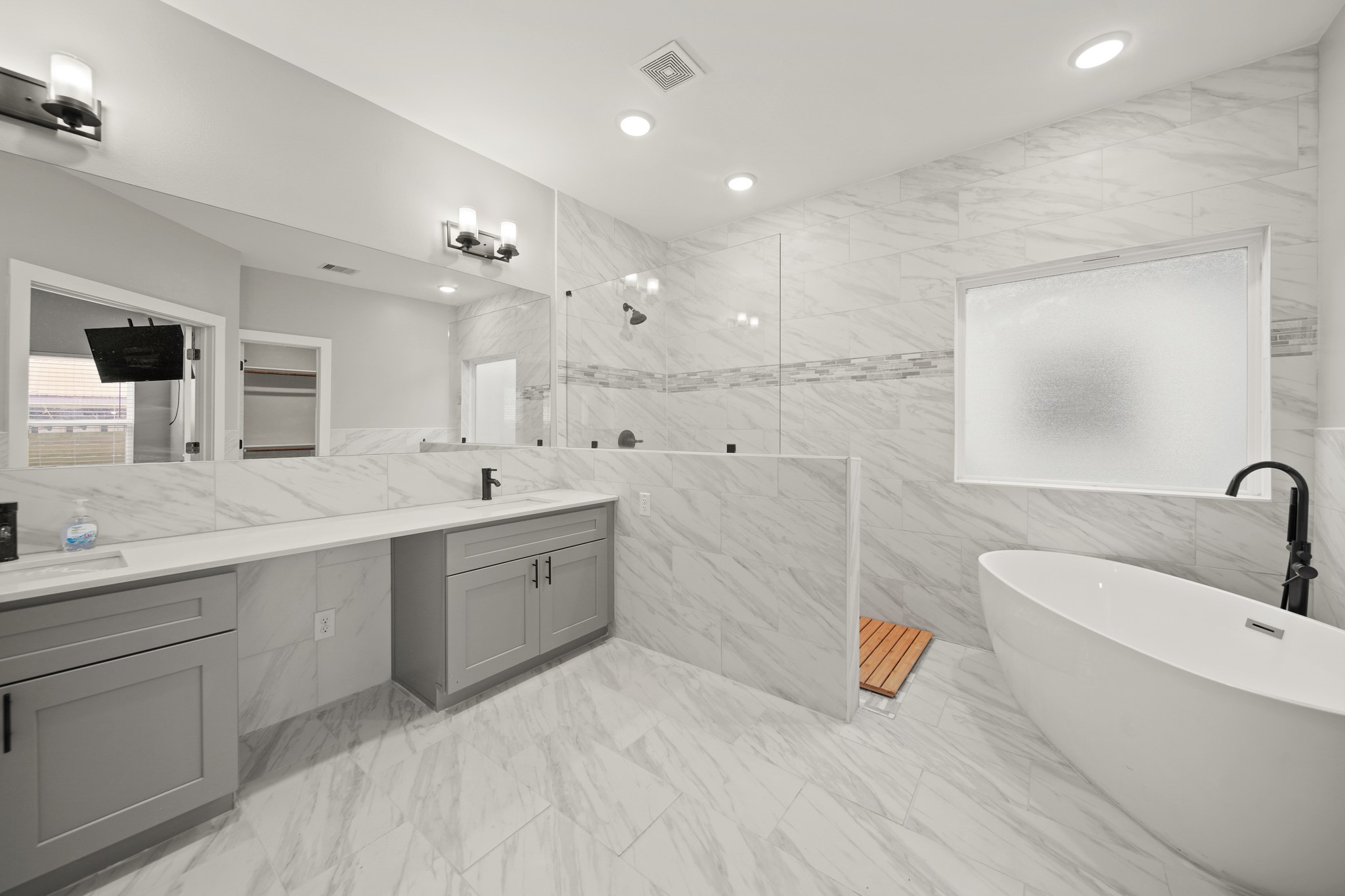 507 Carl Street Houston, TX 77009 - Photo 16 of 25 a spacious bathroom with a double vanity sink a mirror and a bathtub
