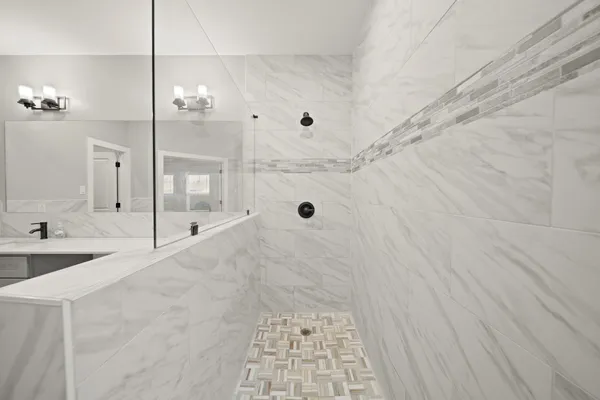 a bathroom with a tub shower vanity and a sink