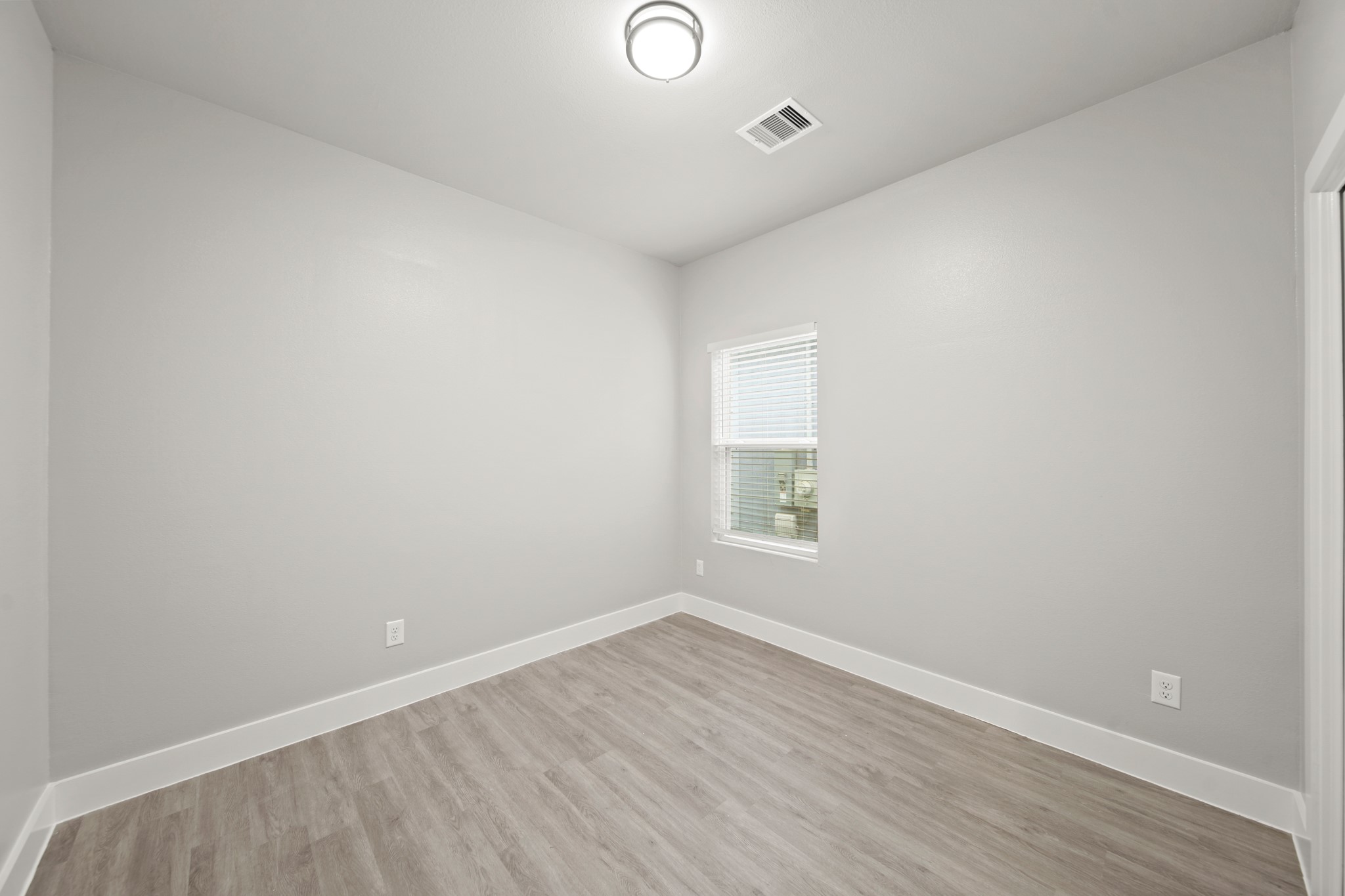 507 Carl Street Houston, TX 77009 - Photo 21 of 25 an empty room with wooden floor and windows