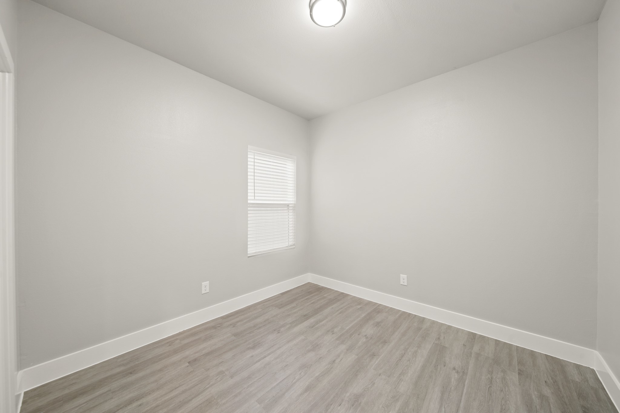 507 Carl Street Houston, TX 77009 - Photo 23 of 25 an empty room with wooden floor and windows