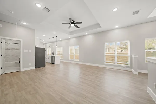 a view of an empty room with a window and wooden floor