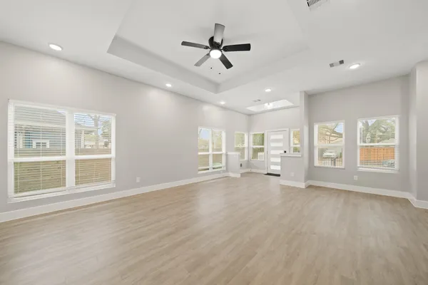 a view of an empty room with a window and wooden floor