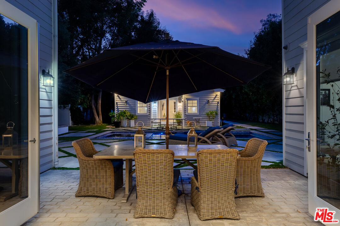 17524 Jayden Lane Encino, CA 91316 - Photo 48 of 52 a view of a patio with a dining table and chairs under an umbrella