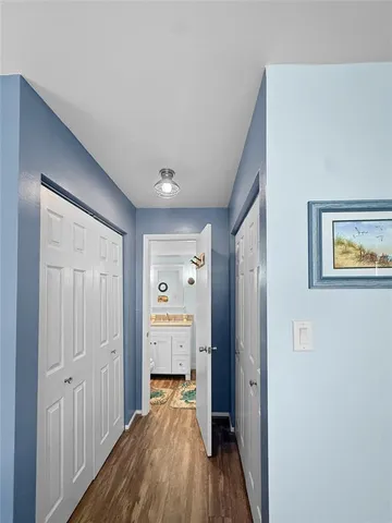 a view of a hallway with wooden floor and closet