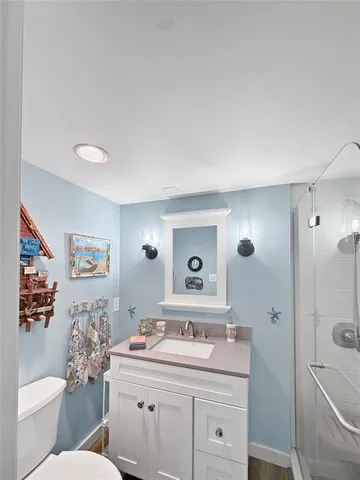 a bathroom with a granite countertop sink mirror vanity and toilet