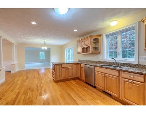 24 Regency Drive Dracut, MA 01826 - Photo 13 of 42 a kitchen with stainless steel appliances granite countertop a sink and wooden cabinets