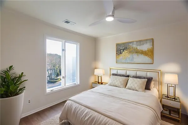 a bedroom with a large bed and a potted plant