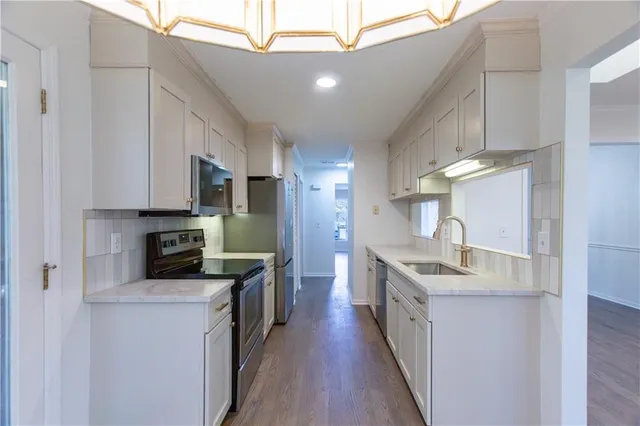a kitchen with cabinets and wooden floor