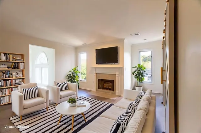 a living room with furniture a fireplace and a flat screen tv