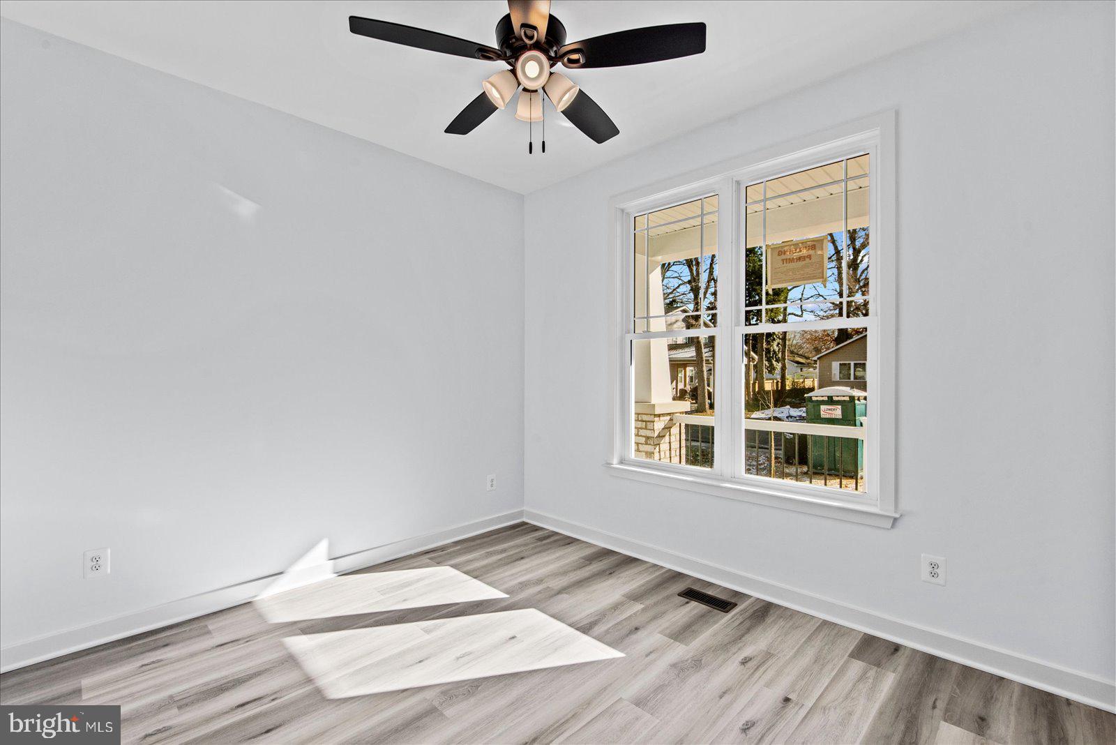 133 6th Street Colonial Beach, VA 22443 - Photo 27 of 34 an empty room with wooden floor chandelier fan and windows