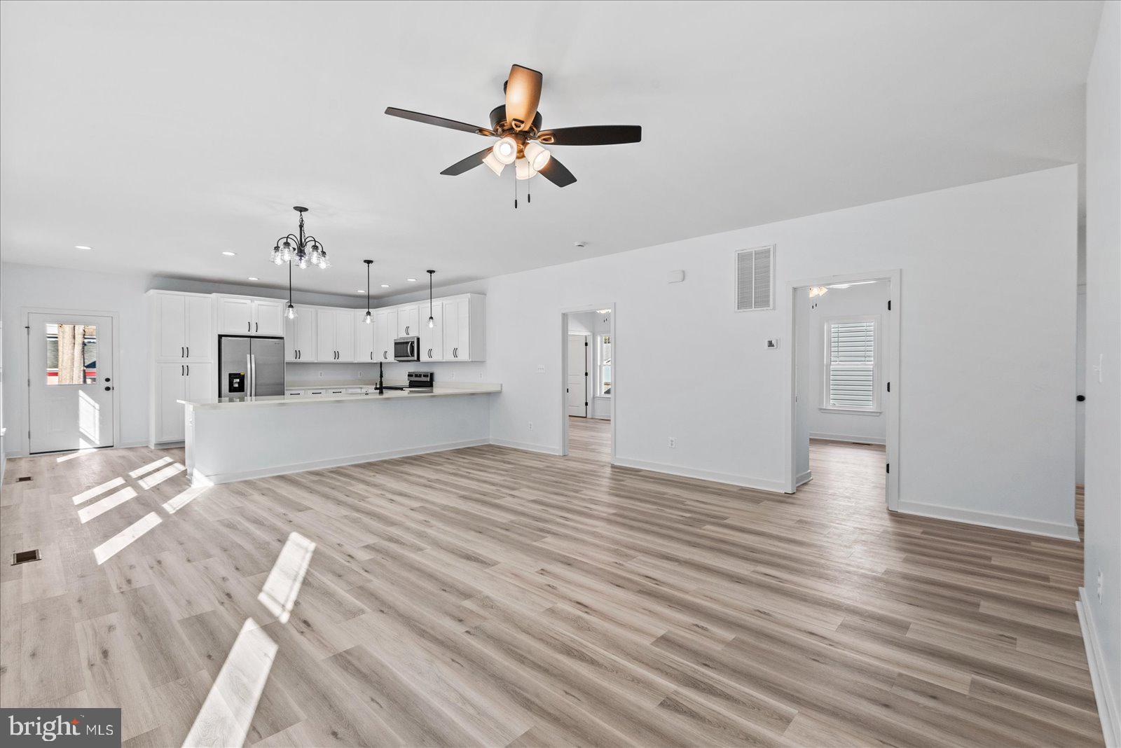 133 6th Street Colonial Beach, VA 22443 - Photo 10 of 34 a view of a livingroom with wooden floor and a ceiling fan