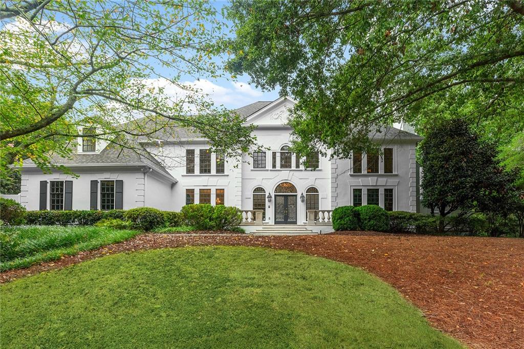 5760 Powers Ferry Road Northwest Sandy Springs, GA 30327 - Photo 1 of 1 a front view of a house with a garden