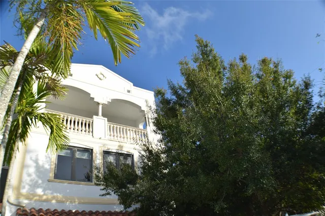 a view of a house with a yard and potted plants