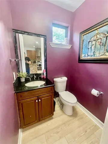 a large white kitchen with a stove a sink dishwasher and a fireplace with wooden floor