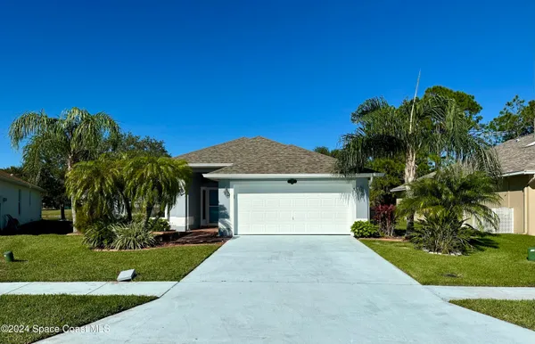 a front view of a house with a yard and a garage