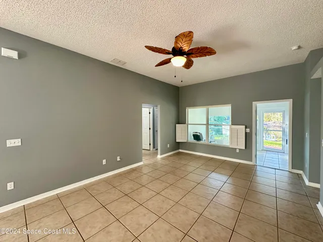 a view of an empty room and window and a kitchen