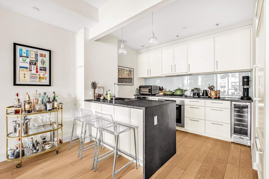 160 East 22nd Street, Unit 10D Manhattan, NY 10010 - Photo 3 of 12 a kitchen with granite countertop white cabinets and refrigerator