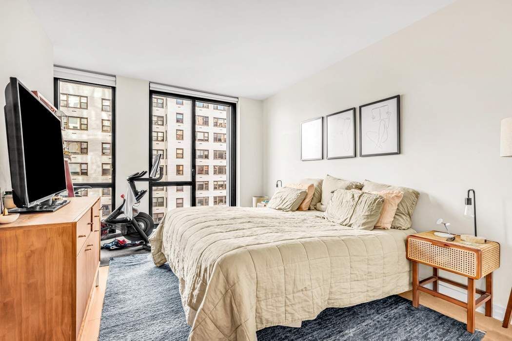 160 East 22nd Street, Unit 10D Manhattan, NY 10010 - Photo 4 of 12 a bedroom with a bed and a flat screen tv