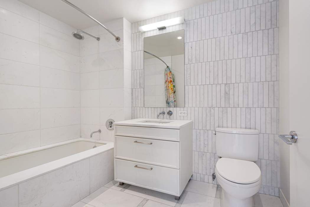 160 East 22nd Street, Unit 10D Manhattan, NY 10010 - Photo 5 of 12 a bathroom with a sink toilet and shower