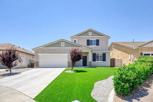 a front view of a house with a garden and yard