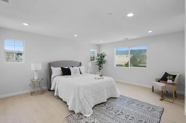a bedroom with a large bed and a potted plant