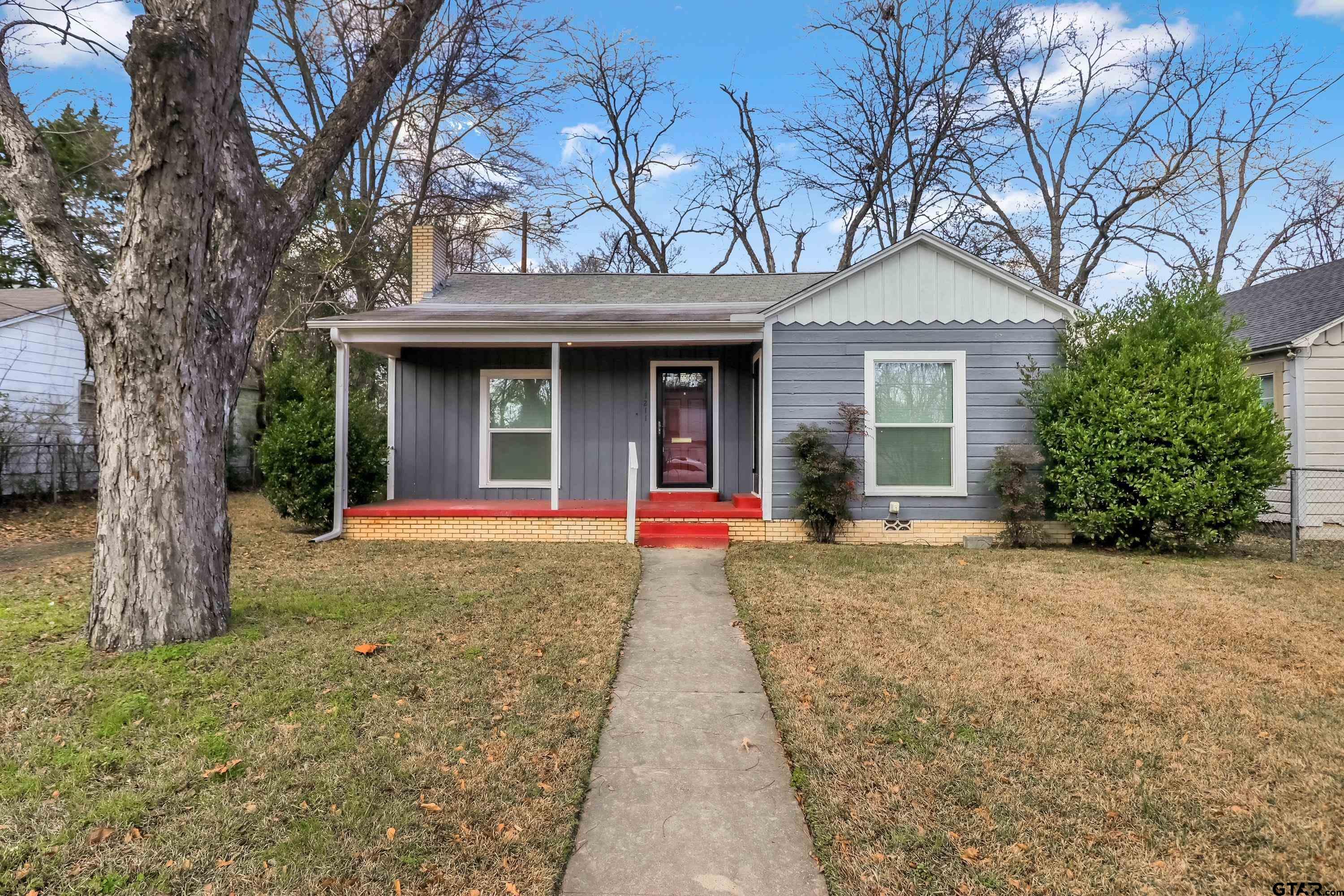 front view of a house with a yard and an trees