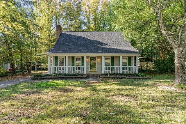 a front view of a house with a yard and shrubs