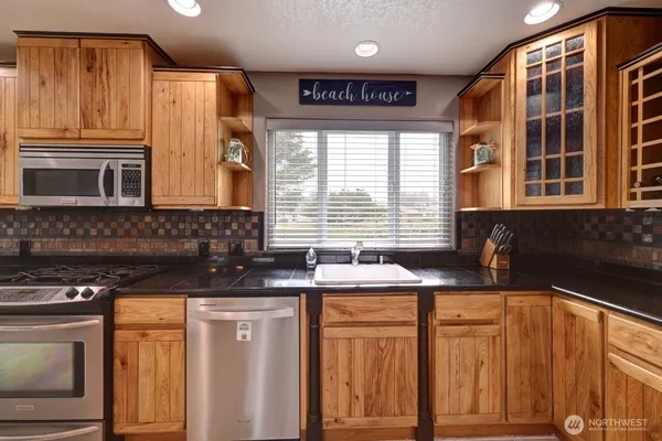 a kitchen with stainless steel appliances granite countertop a sink stove and cabinets