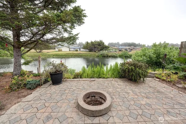 a view of a backyard with water fountain and large trees