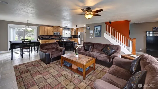 a living room with furniture a flat screen tv and kitchen view