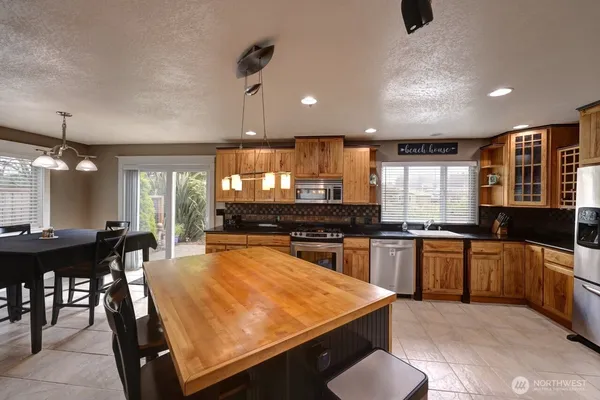 a kitchen with stainless steel appliances granite countertop a sink a stove and a refrigerator