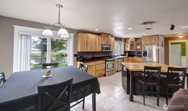 a kitchen with a dining table chairs and refrigerator