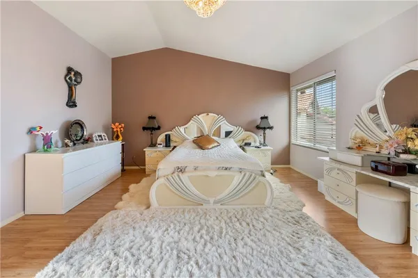 a bedroom with a bed a fireplace and a flat screen tv