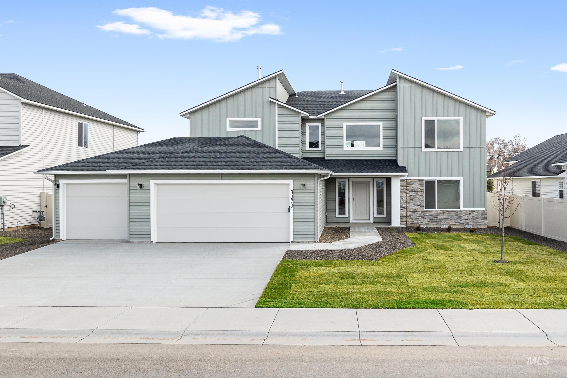 View of front of property featuring an attached garage, roof with shingles, driveway, and stone siding