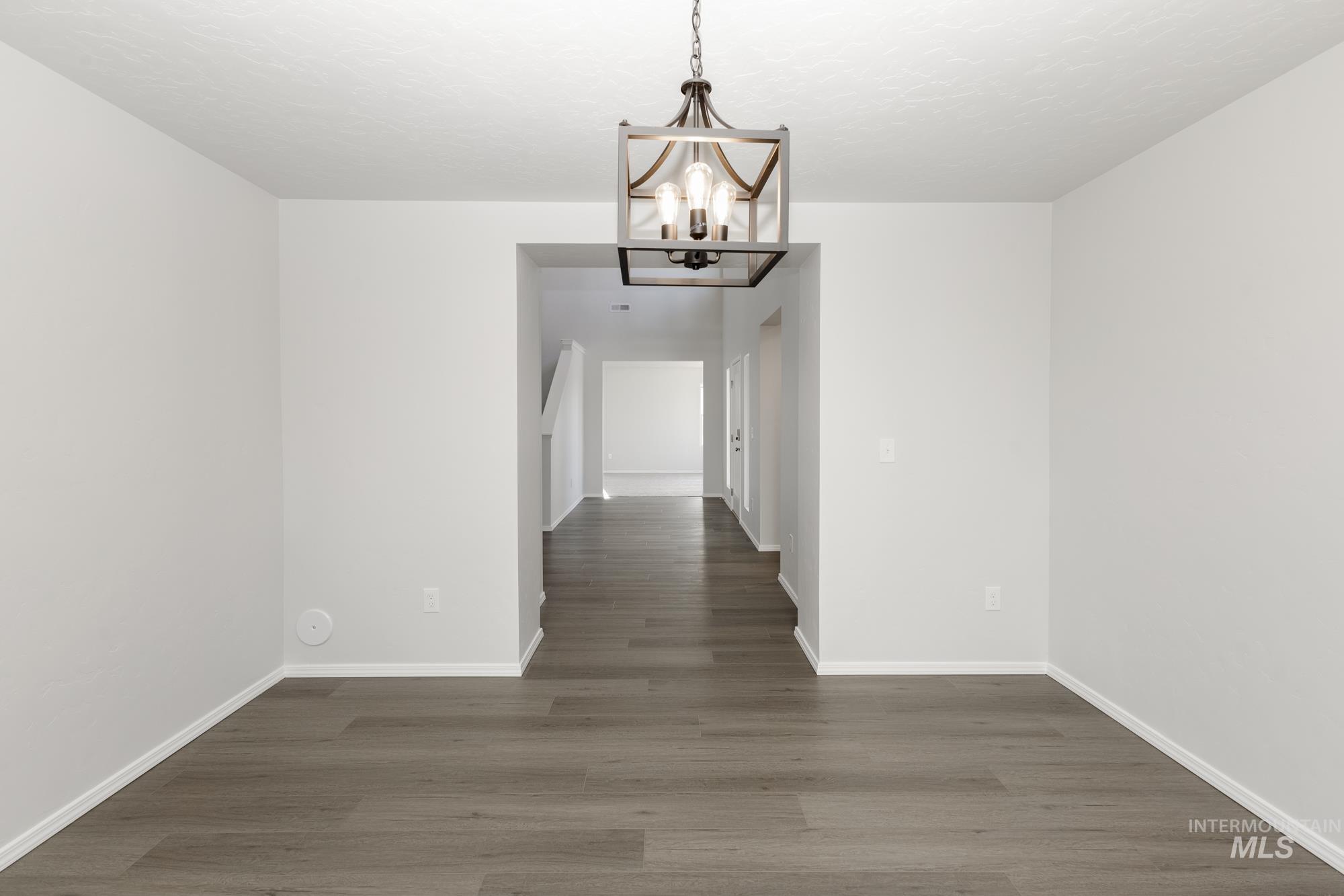 3070 South Maple Rnch Way Nampa, ID 83686 - Photo 16 of 33 Unfurnished dining area with a chandelier and dark wood-style floors