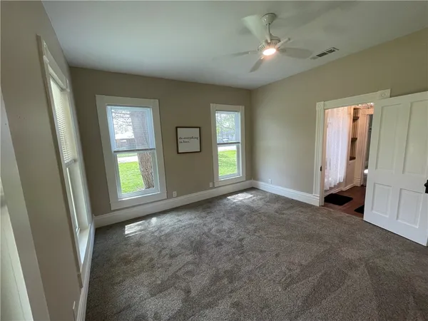 a view of a livingroom with a ceiling fan and window