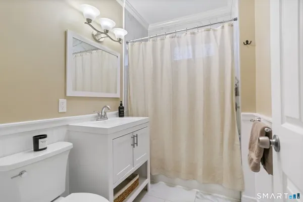 a bathroom with a sink a toilet and shower curtain