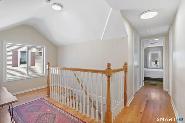 a view of a hallway with a window and wooden floor