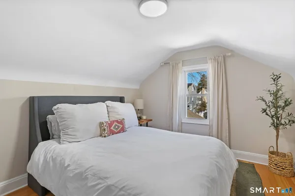 a bedroom with a large bed and a potted plant