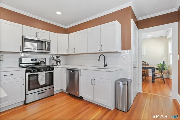 a kitchen with stainless steel appliances granite countertop a stove a sink and a microwave