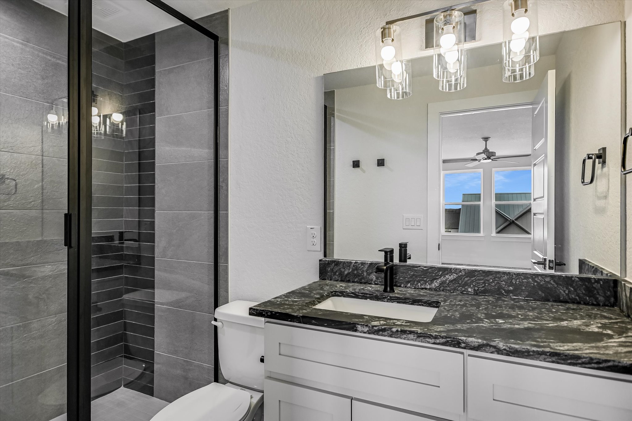 32 Peace Pipe Wimberley, TX 78676 - Photo 12 of 20 Bathroom with a textured wall, a shower stall, vanity, and ceiling fan