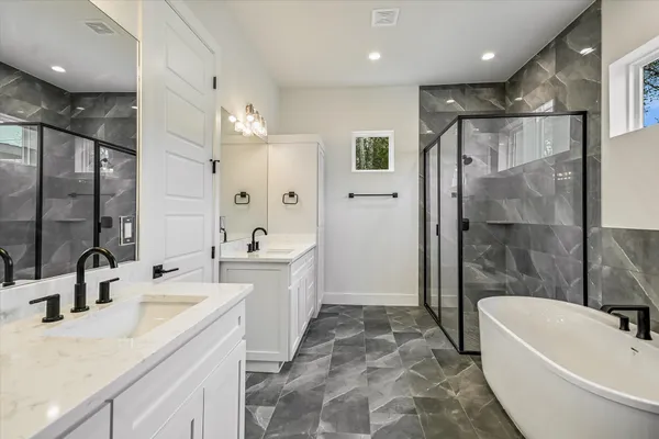 a bathroom with a tub sink shower and mirror