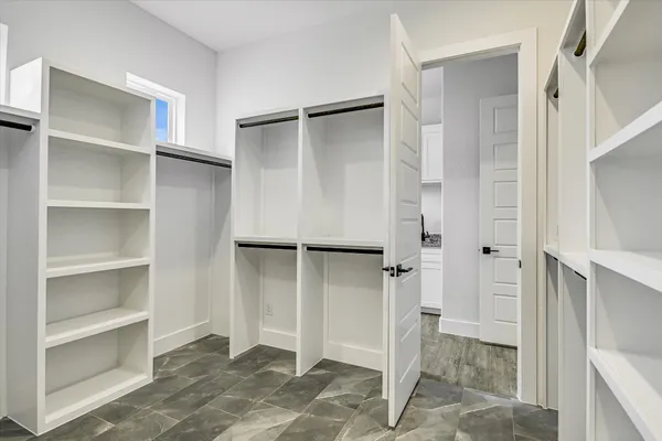 a view of walk in closet with empty racks