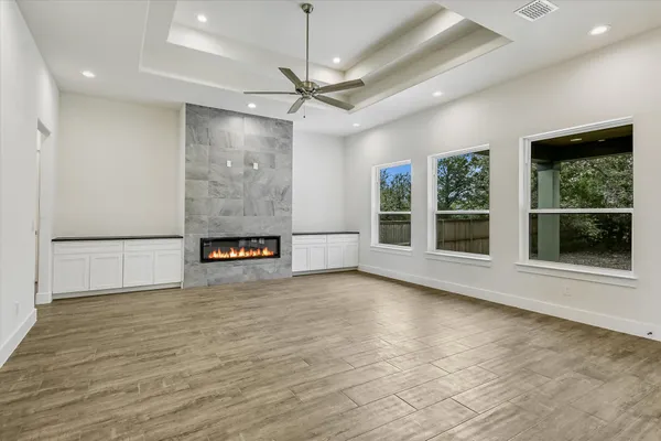 a view of an empty room with a window and kitchen view