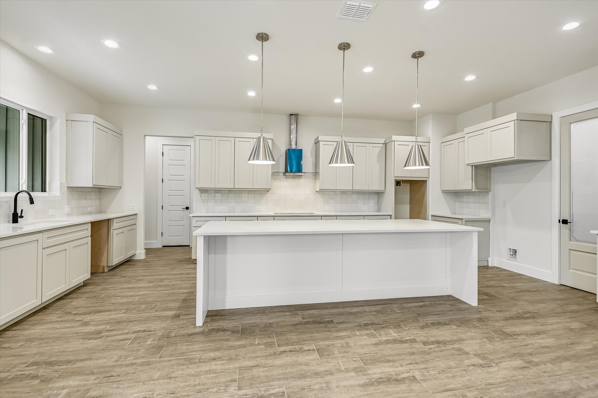 32 Peace Pipe Wimberley, TX 78676 - Photo 8 of 20 Kitchen with pendant lighting, a large island, decorative backsplash, and light stone countertops