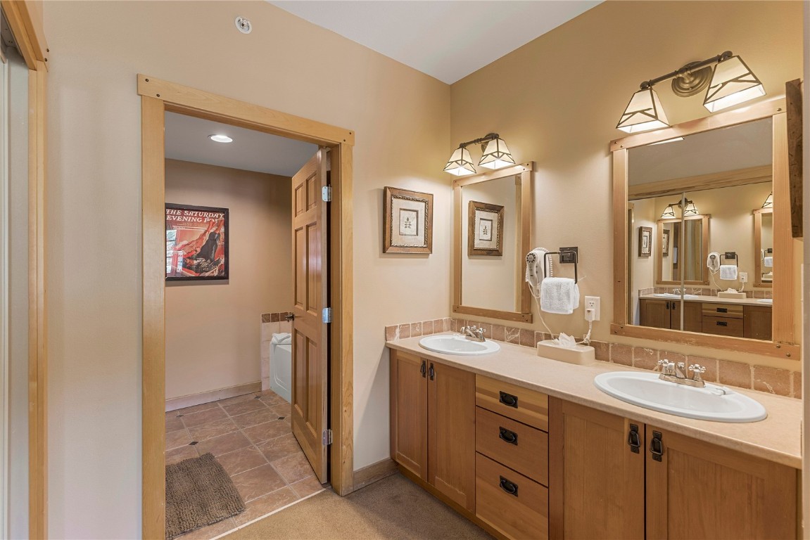 910 Copper Road, Unit 219 Copper Mountain, CO 80443 - Photo 18 of 33 a bathroom with a double vanity sink and a mirror