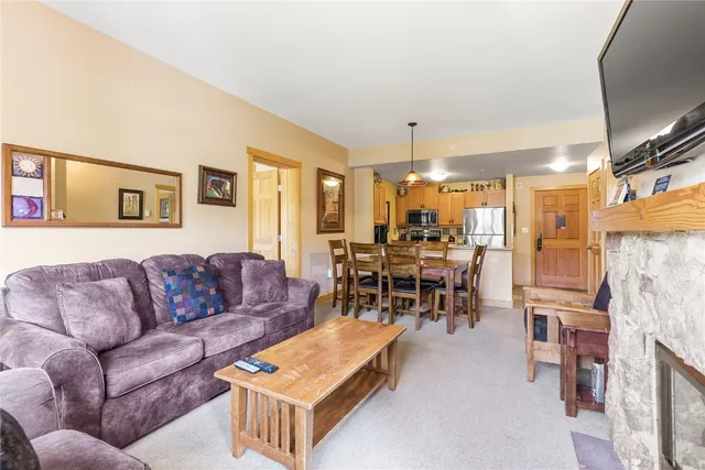 a living room with furniture and a dining table with kitchen view