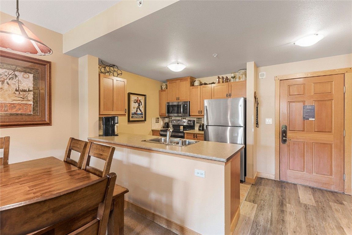 910 Copper Road, Unit 219 Copper Mountain, CO 80443 - Photo 9 of 33 a view of a kitchen with kitchen island a dining table chairs stainless steel appliances and cabinets