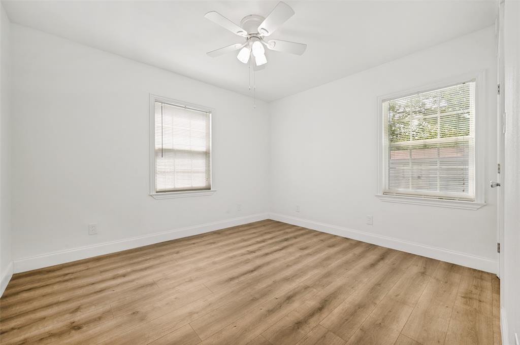 2316 Cunningham Street Irving, TX 75062 - Photo 17 of 22 Room featuring wood-finish flooring, white baseboards, and bright white walls