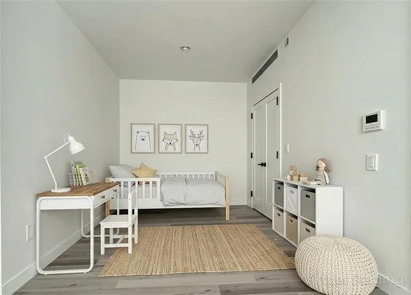 a bedroom with a bed and wooden floor